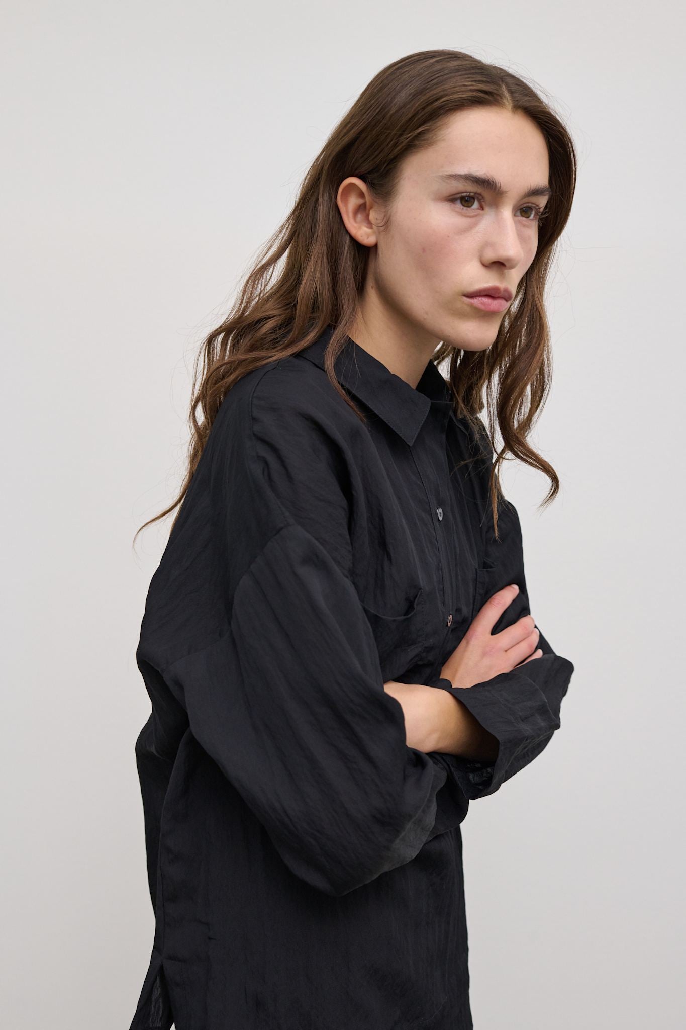 Model wearing Andrea Shirt – Lightweight black shirt with relaxed fit and straight sleeves.