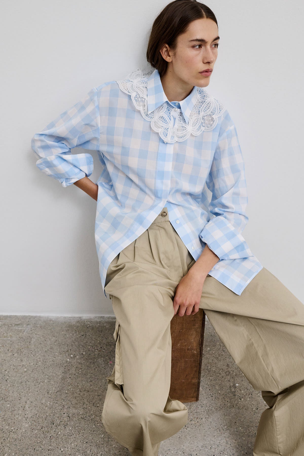 Model sitting while wearing the Vega bold checked shirt, showcasing the blue checked cotton shirt design.