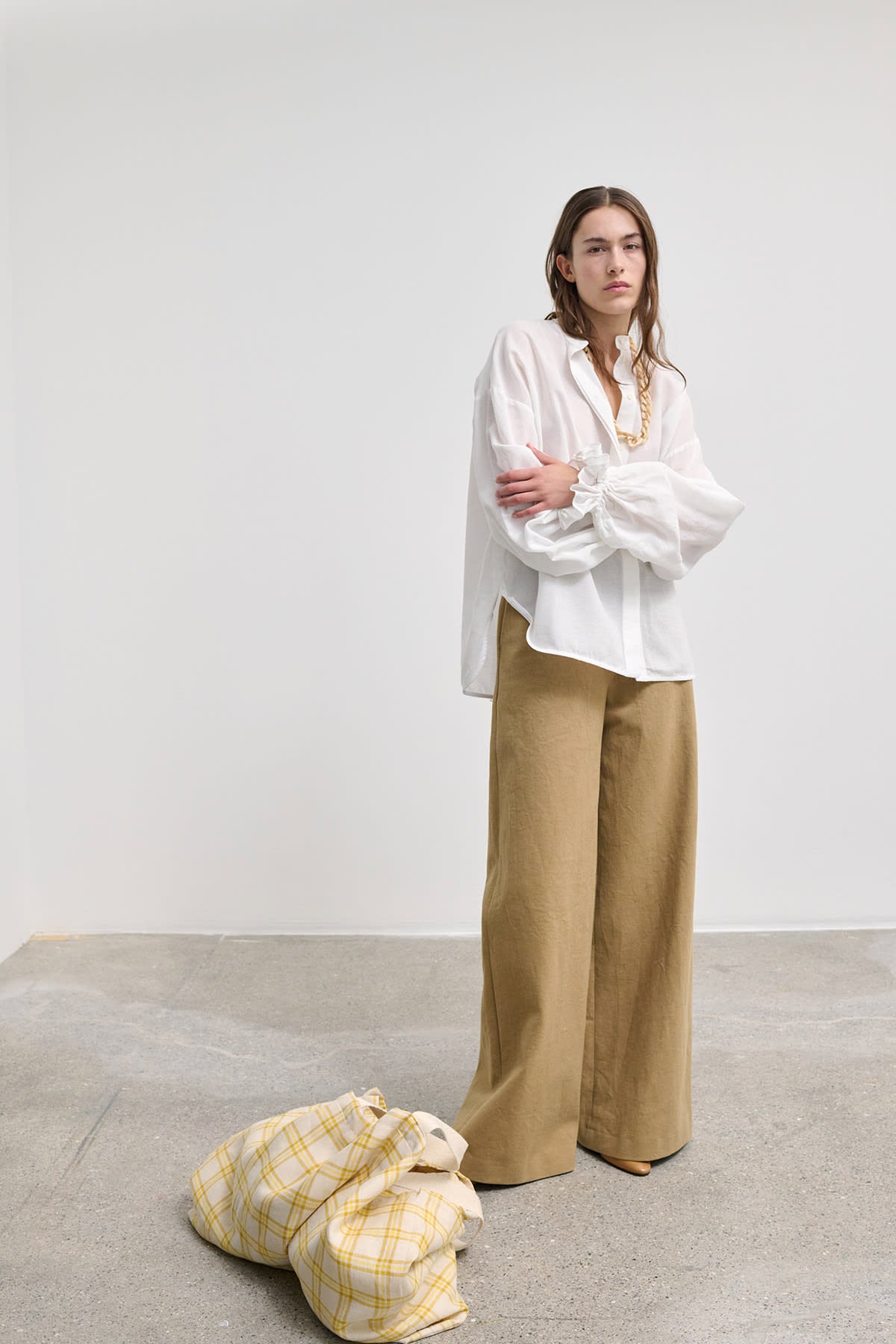 Model wearing Heather white cotton blouse with voluminous sleeves, styled with soft draping.