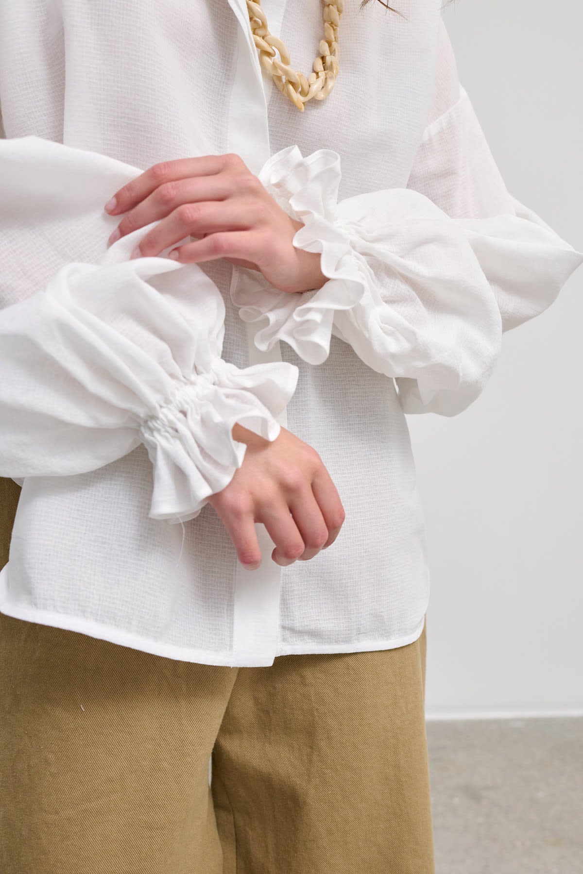 Side view of Heather white cotton blouse with voluminous sleeves, showcasing its relaxed silhouette.