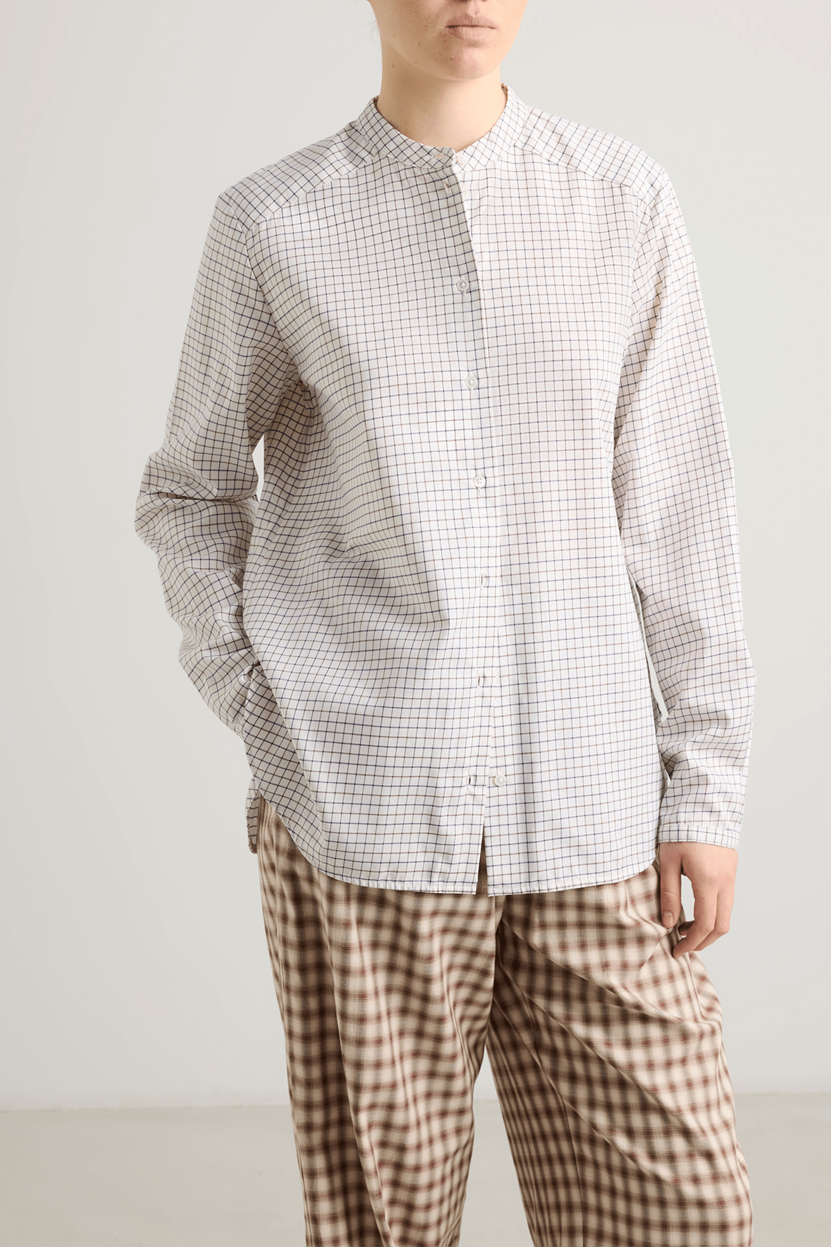 Model wearing Bea shirt with straight silhouette, stand collar and raw-edge sleeves.
