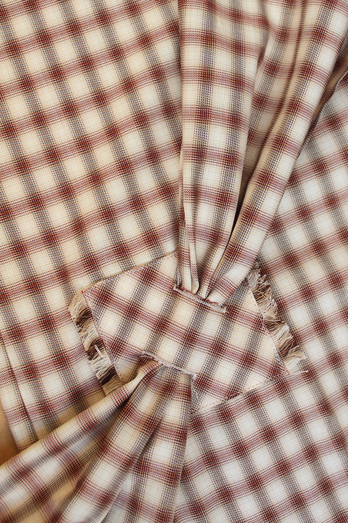 Close-up of Bene cotton shirt with asymmetrical sash.