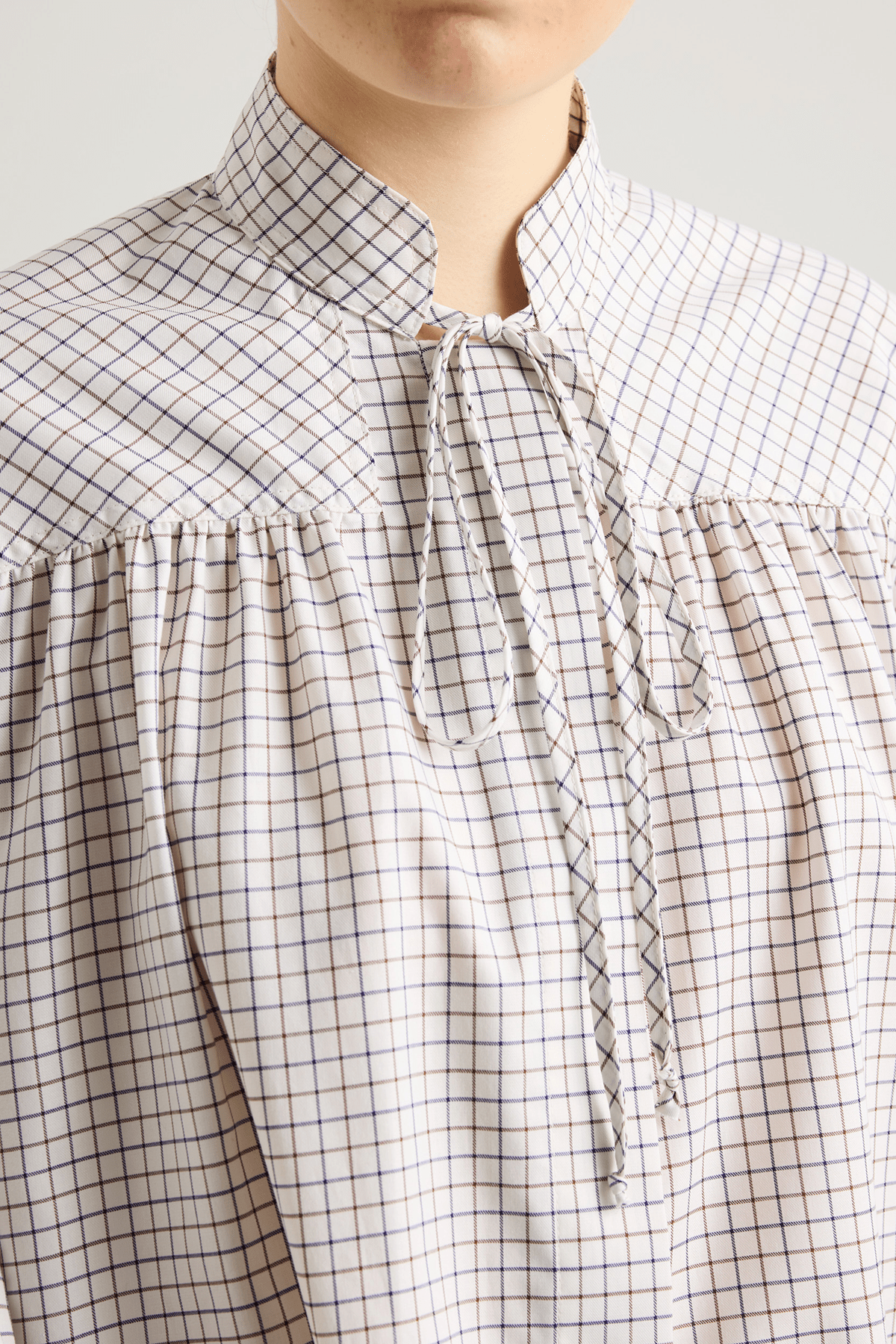 Model wearing Frances shirt in brushed checked cotton and voluminous gathered sleeves.