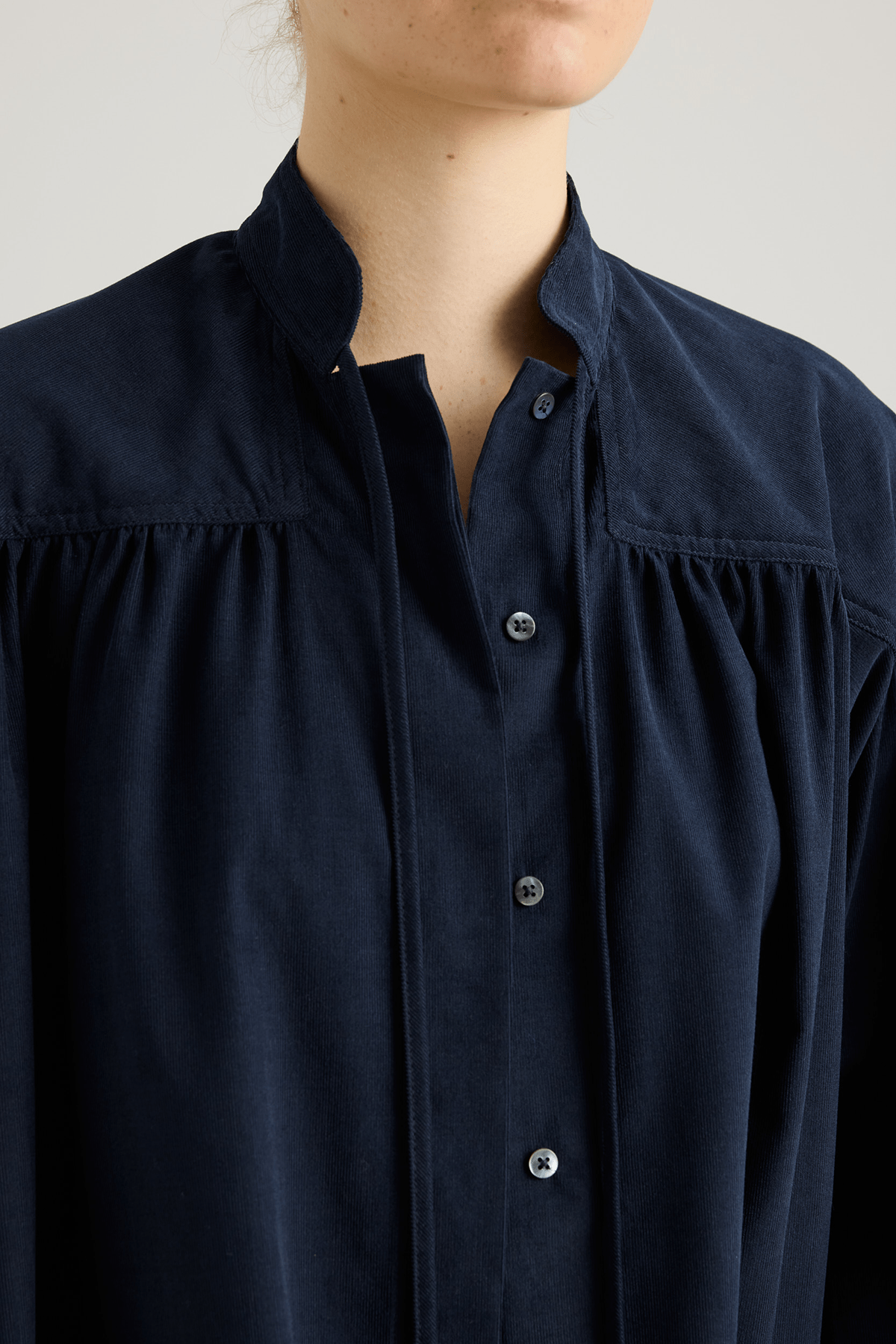 close up Navy shirt with a tie-neck detail, front button closure