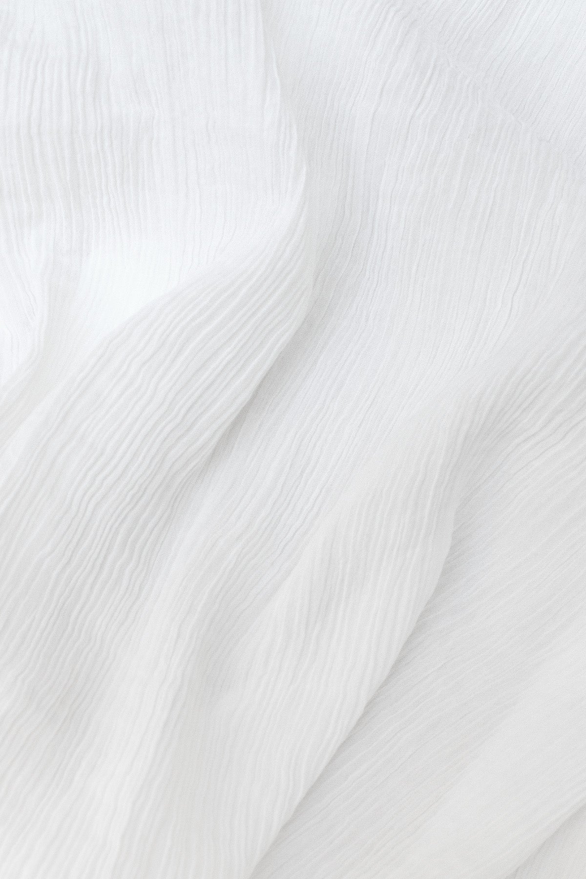 Close-up of the tailored cotton shirt, showing the airy crinkled cotton fabric.