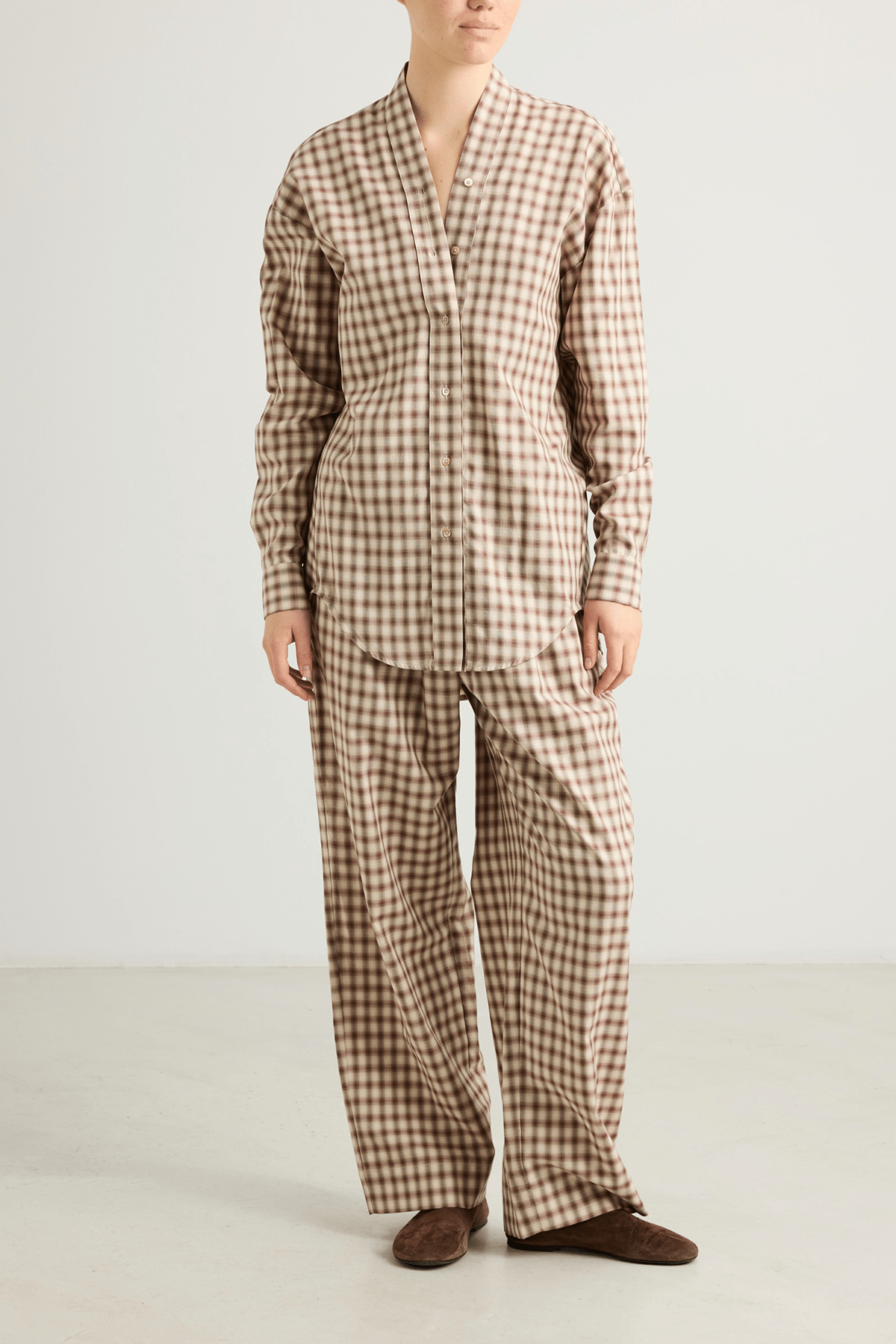 Model wearing Kendel cotton straight-leg trousers in warm graham check.