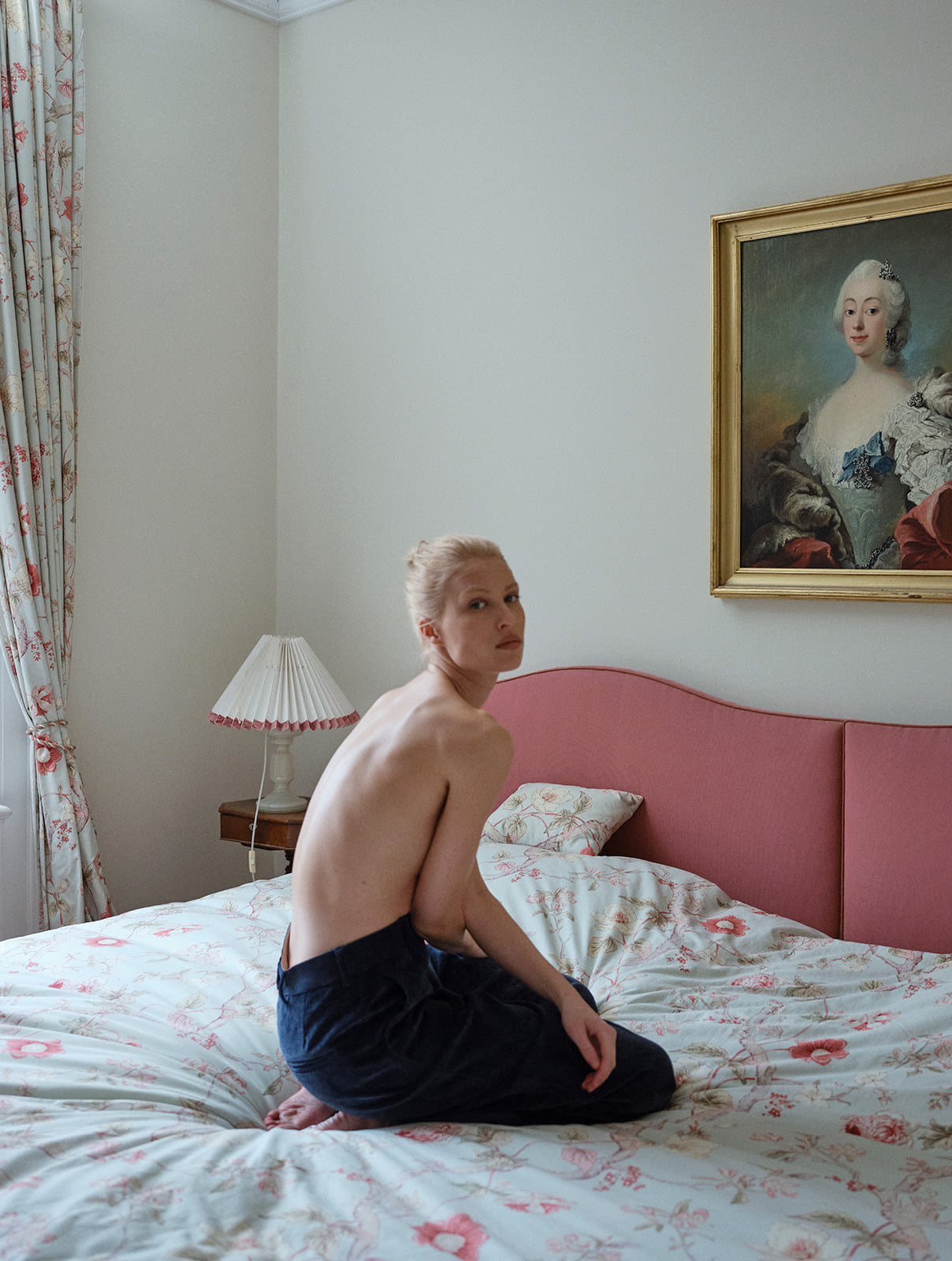 blonde girl sitting in bed wearing girl in navy corduroy trousers