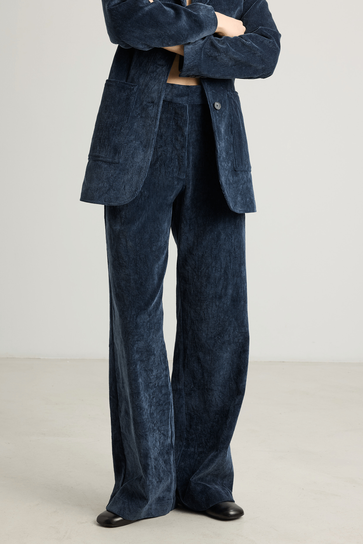 Model wearing Kosta navy blue wide-leg corduroy trousers.
