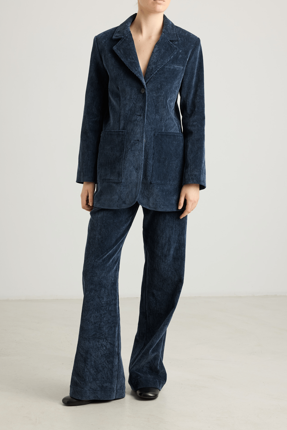 Model wearing Kosta navy blue wide-leg corduroy trousers.
