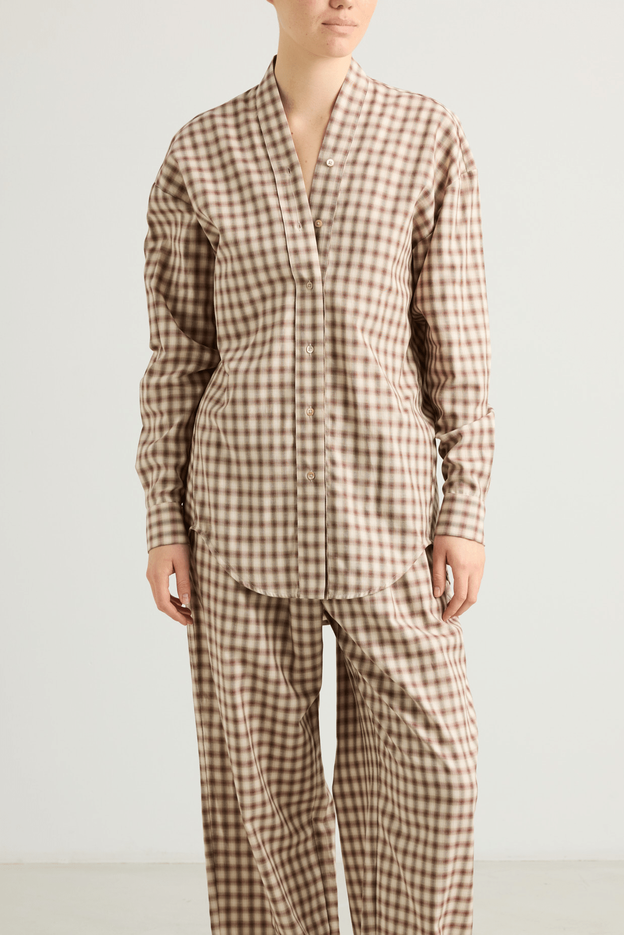 Model wearing the Mina shirt with V-neckline and draped back detail.