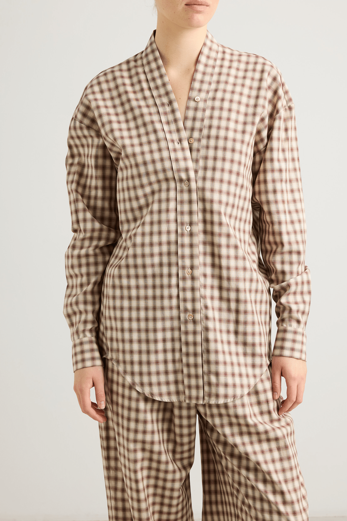Model wearing the Mina shirt with V-neckline and draped back detail.