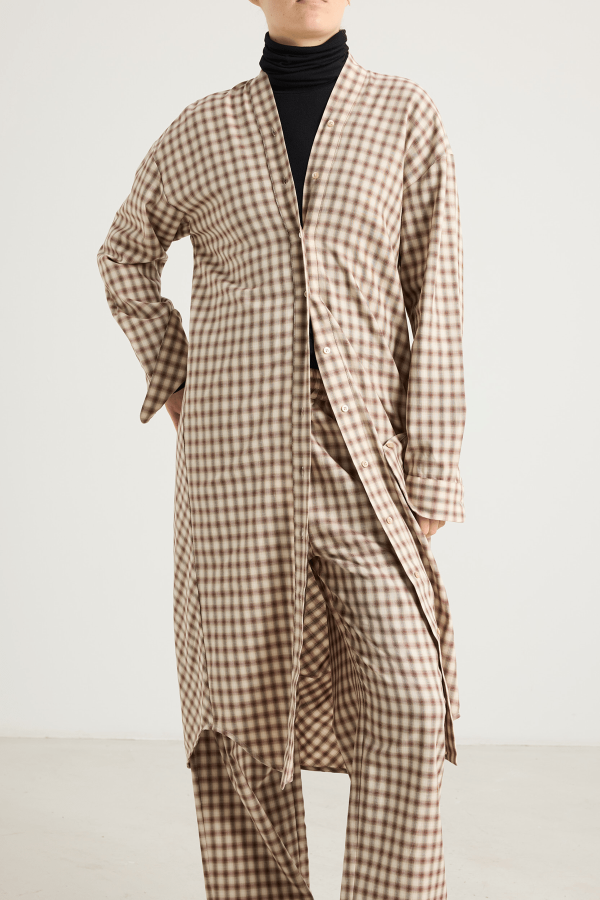 Model wearing The Minal shirt dress with V-neckline and draped back.