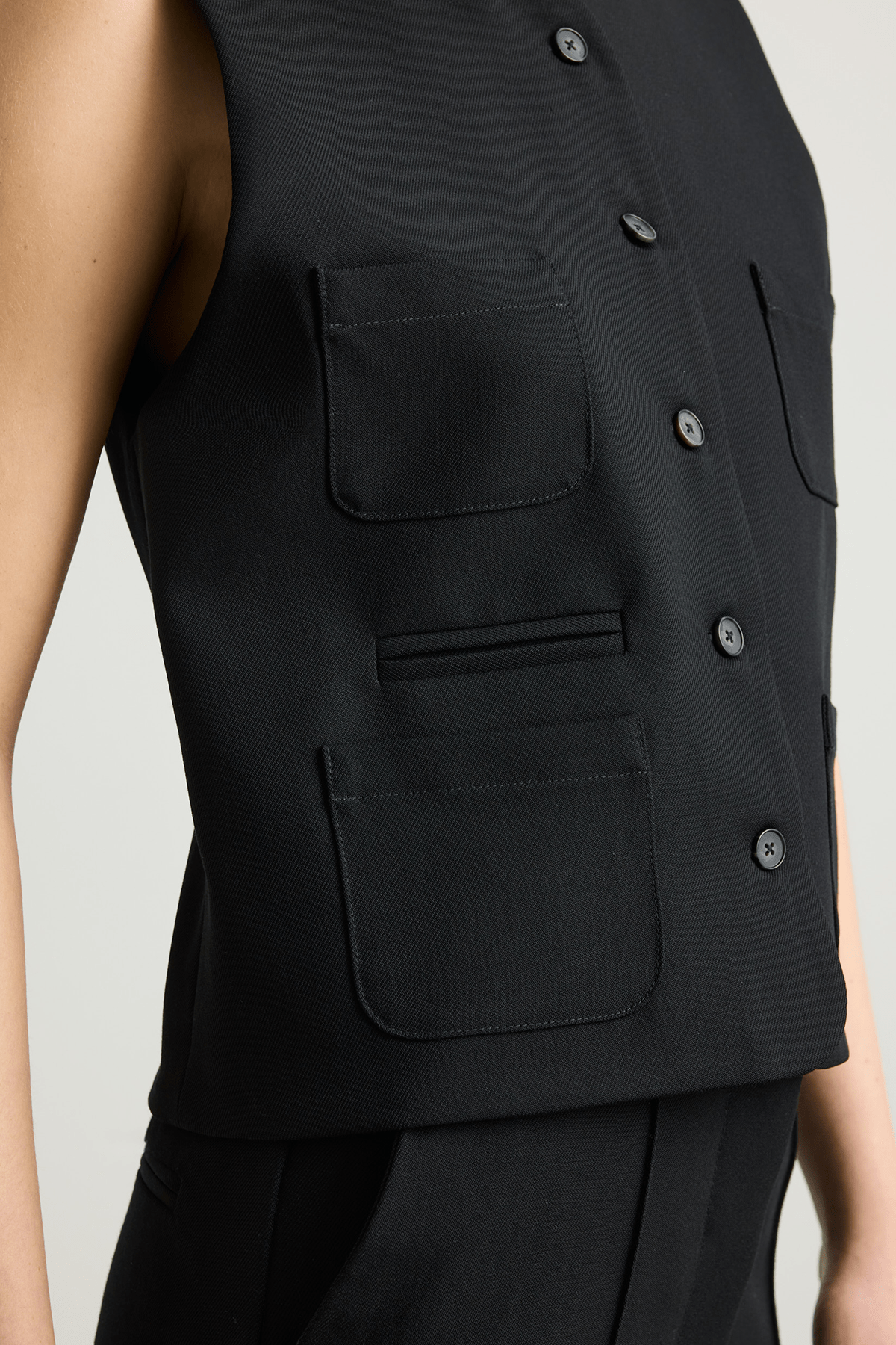 Model wearing black Tinnie vest in cashmere–virgin wool.