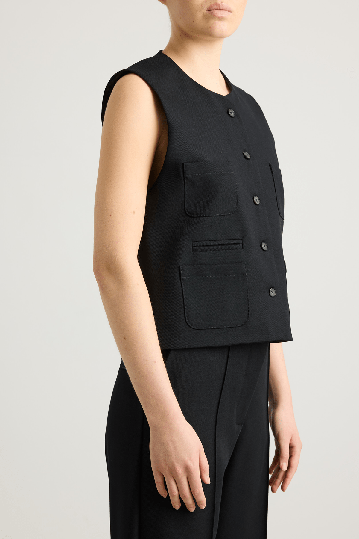 Model wearing black Tinnie vest in cashmere–virgin wool.