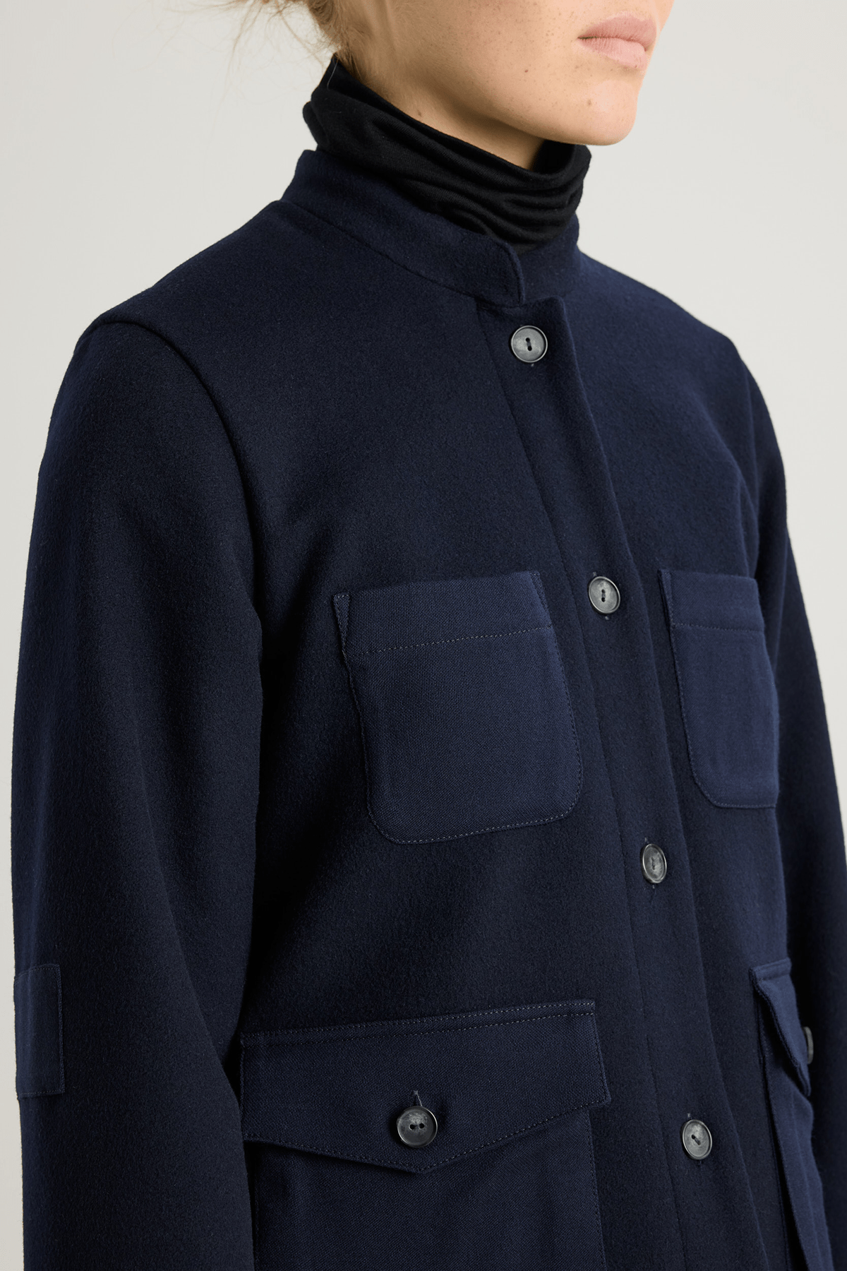 Model wearing the Torni wool jacket in Nightsky with stand collar and contrast patch pockets.