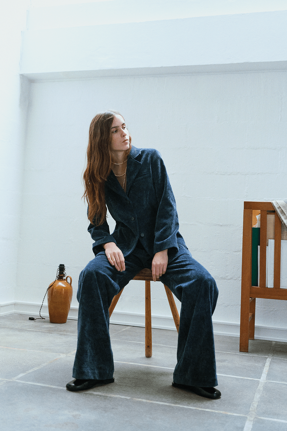 girl sitting on chair in navy curduroy set