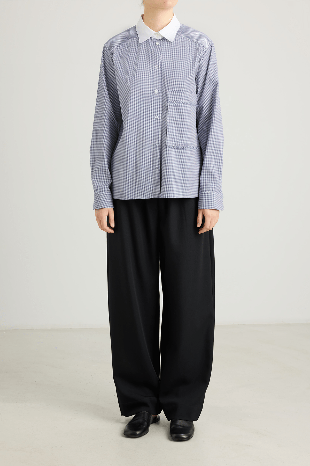 girl wearing blue check shirt with contrat collar and black pants