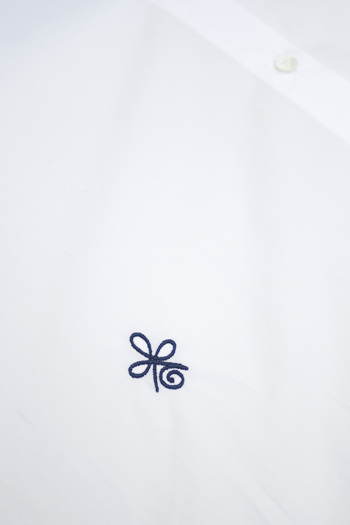 close up white shirt with blue embroidery