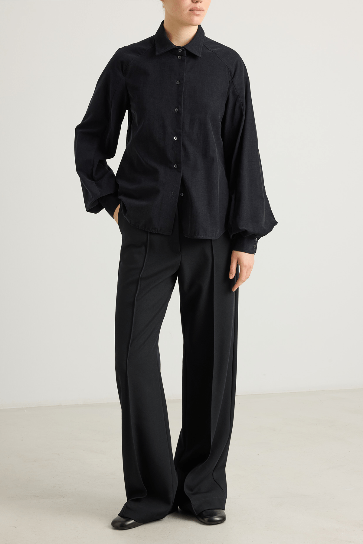 girl in black shirt big sleeves and black trousers