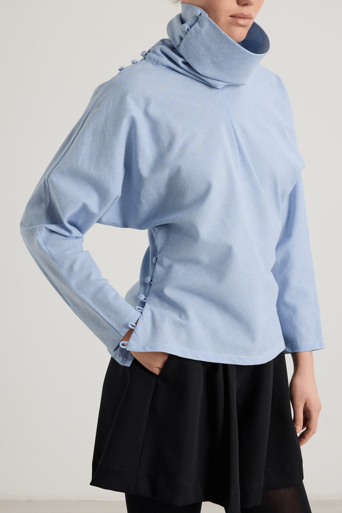 girl in blue houndstooth top with asymmetrical buttoned neckline
