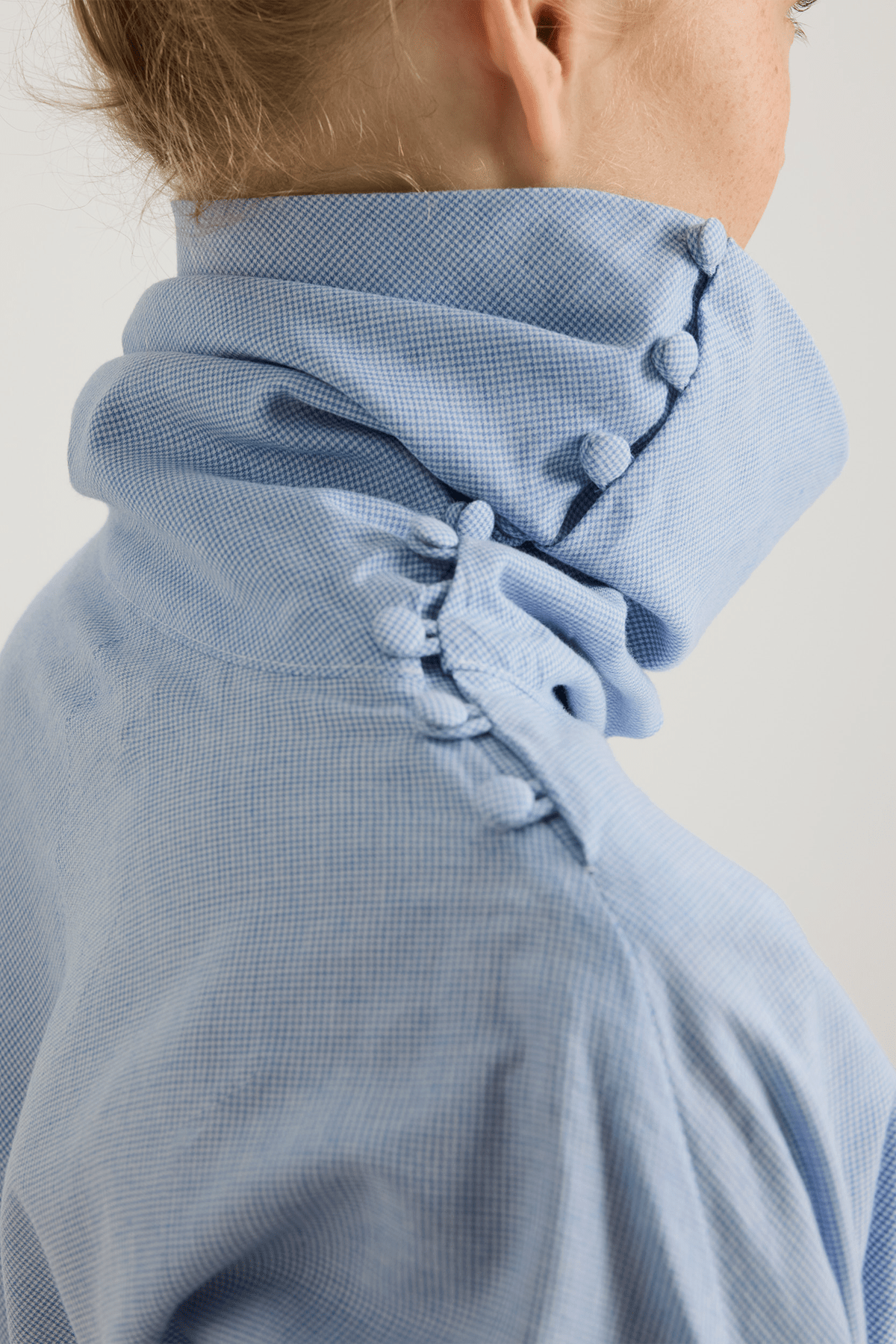 close up blue houndstooth top with buttoned detail