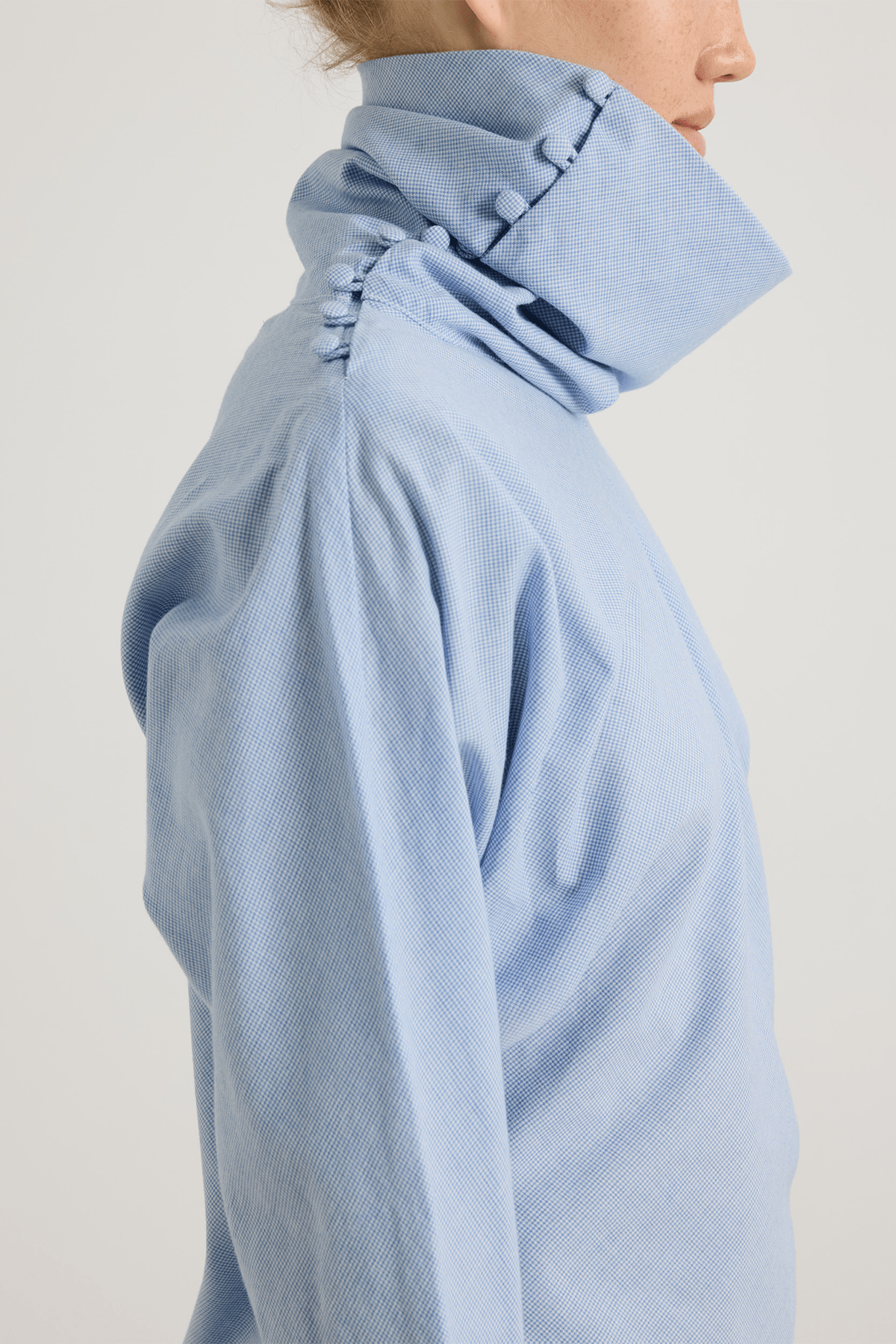 girl in blue houndstooth top with buttoned neckline