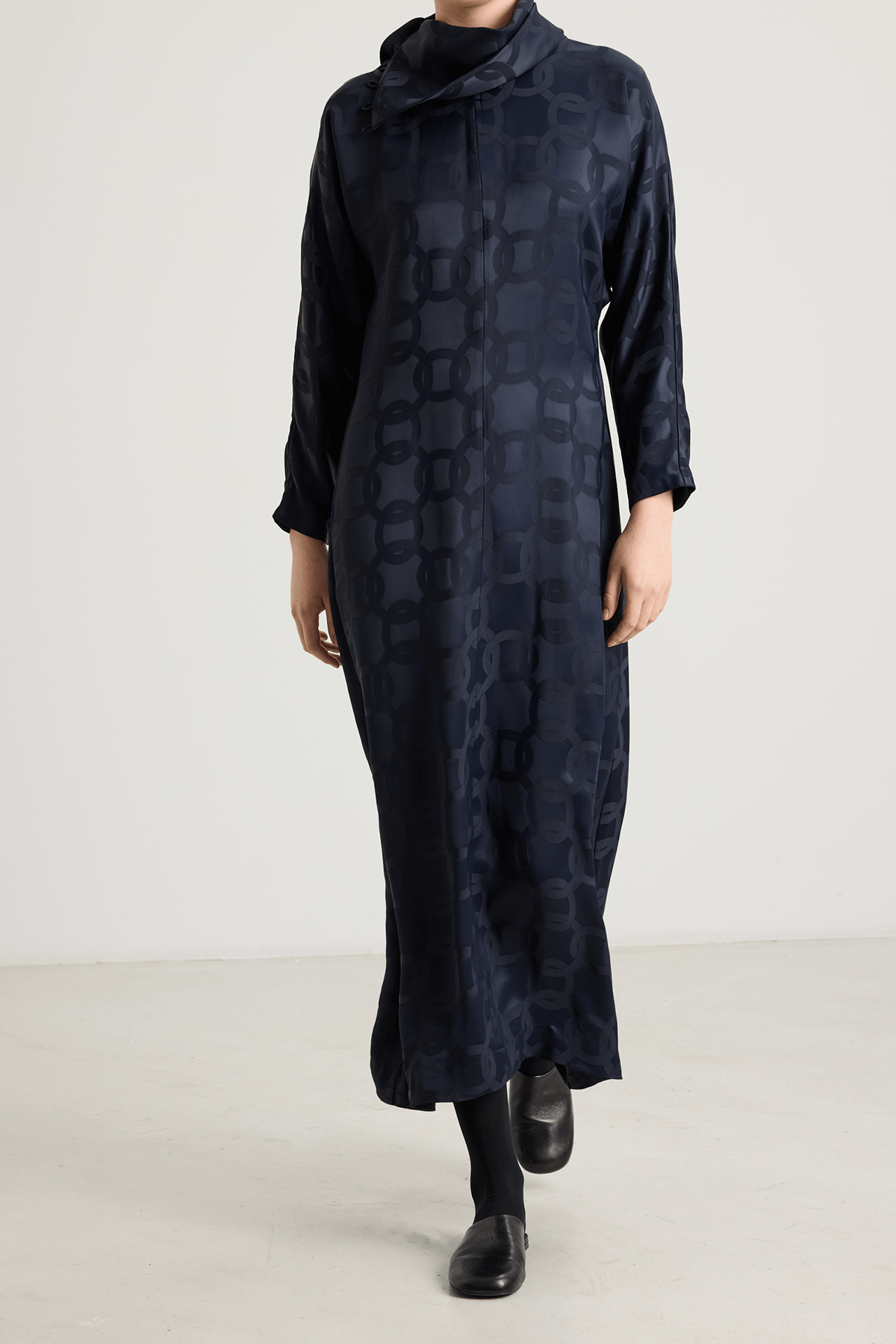 girl in black dress with an asymmetrical neckline and subtle geometric jacquard pattern.