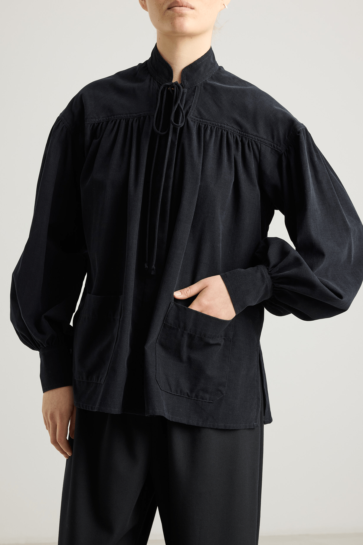 girl in black checked shirt with a tie-neck detail, front button closure