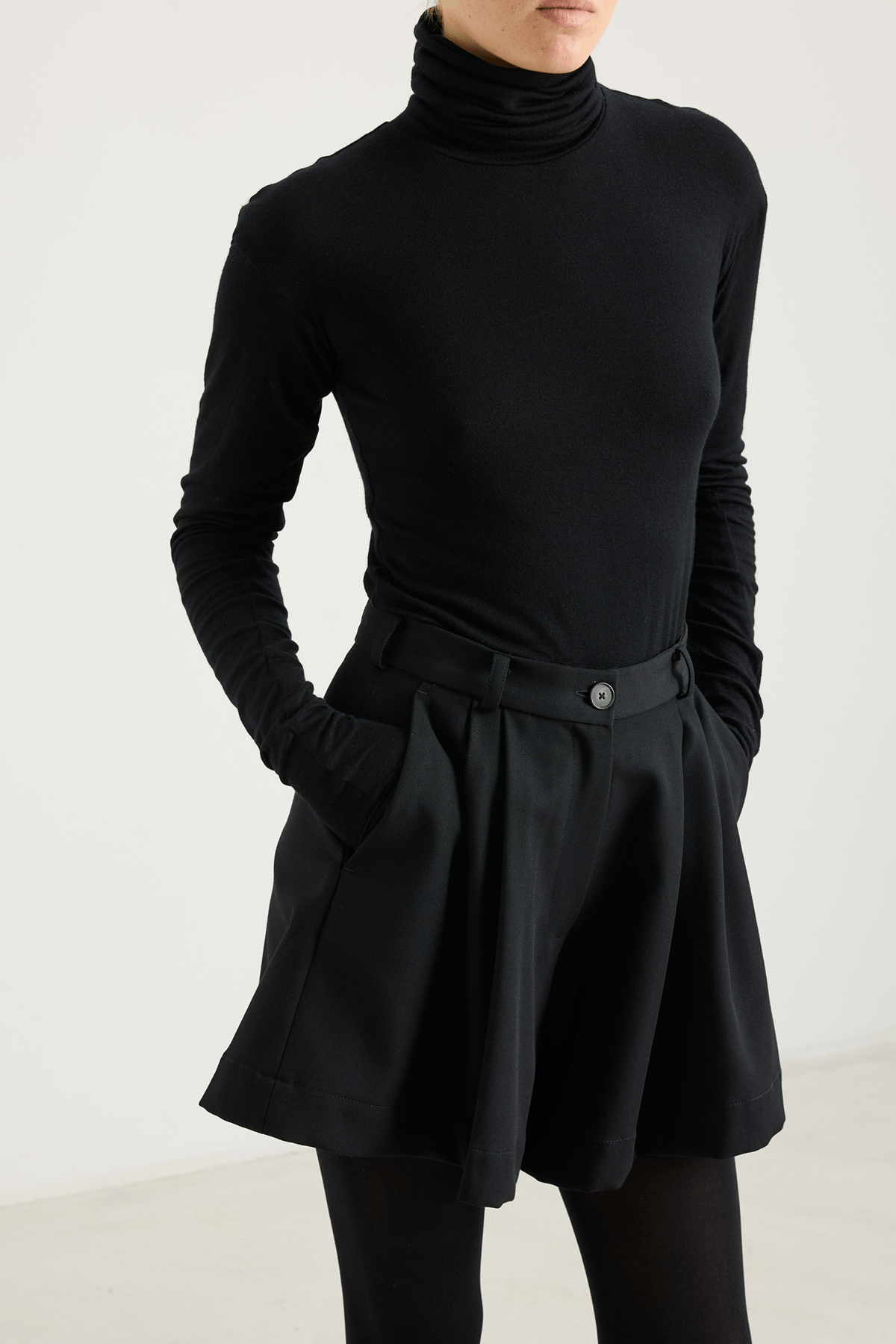 girl in black shorts and black turtleneck