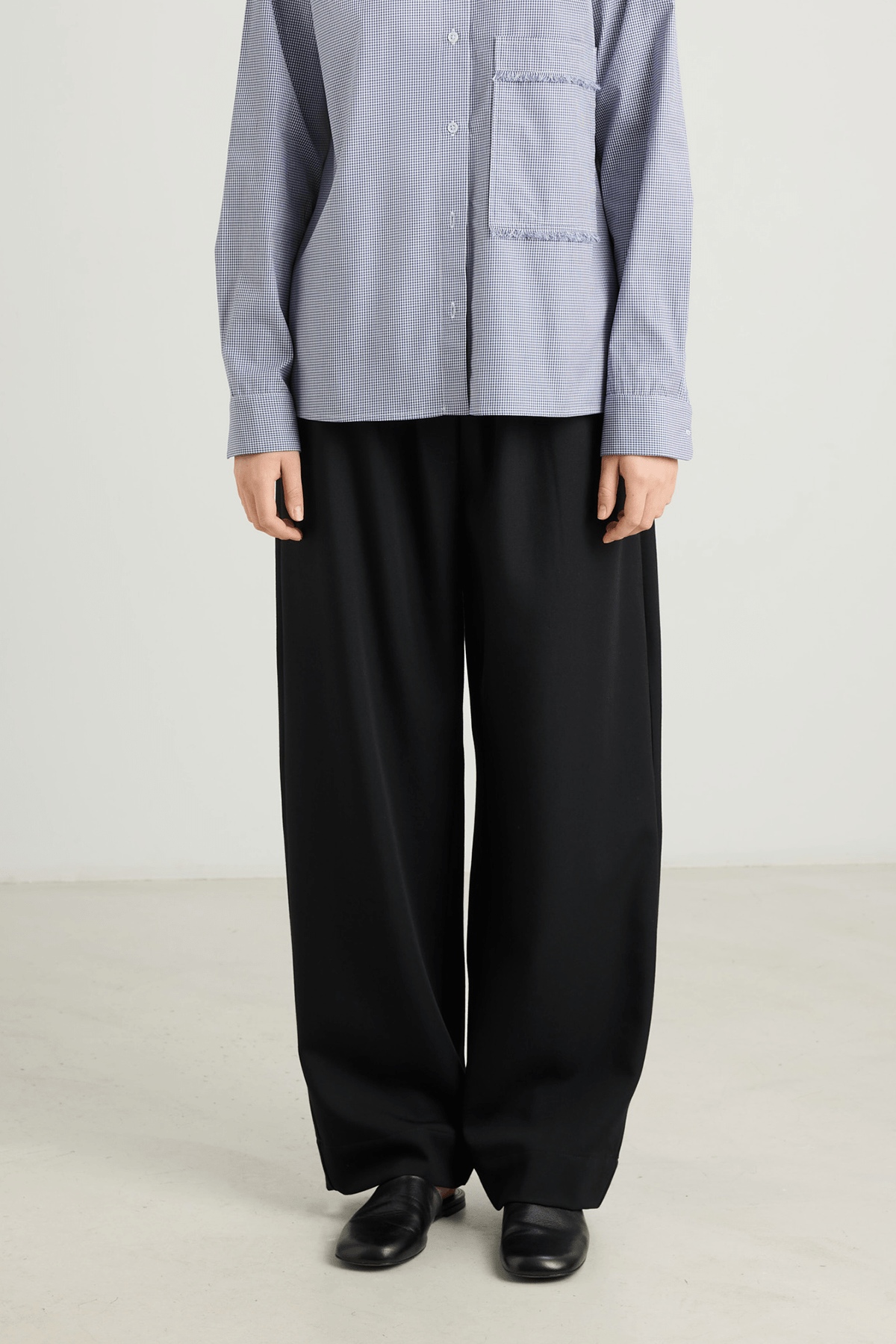 girl in black trousers and blue check shirt