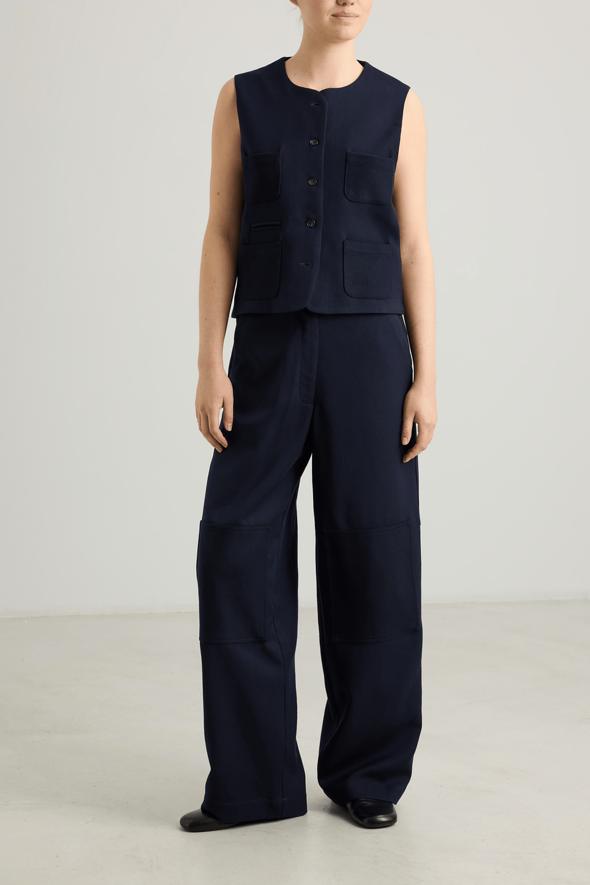 girl in Navy straigt leg trousers and navy vest