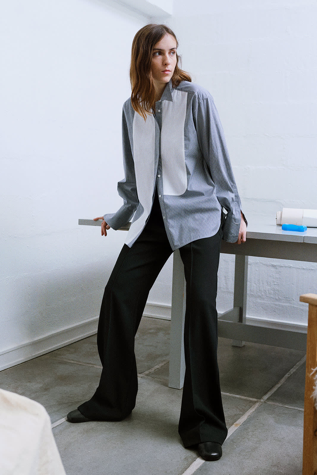 brunette in blue check shirt with white tuxedo details, sitting on a table