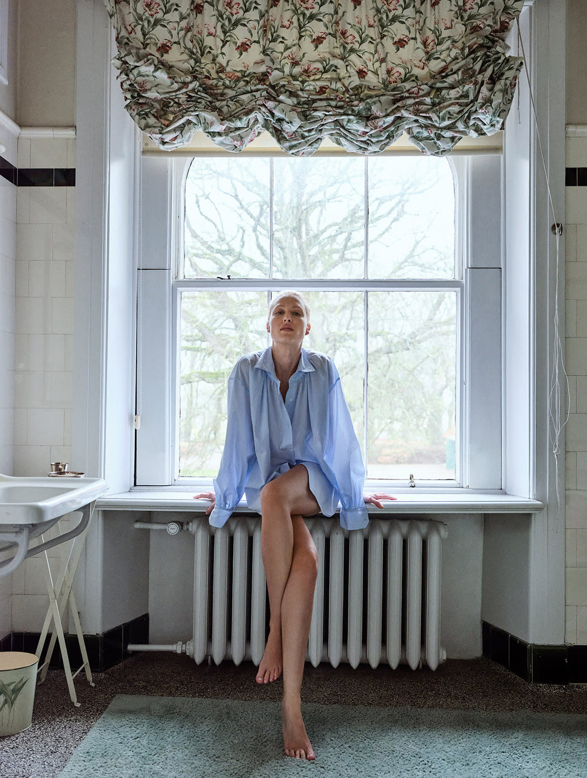 blonde girl in a light blue shirt in a bathroom
