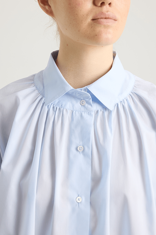 close up girl in a light blue cotton shirt