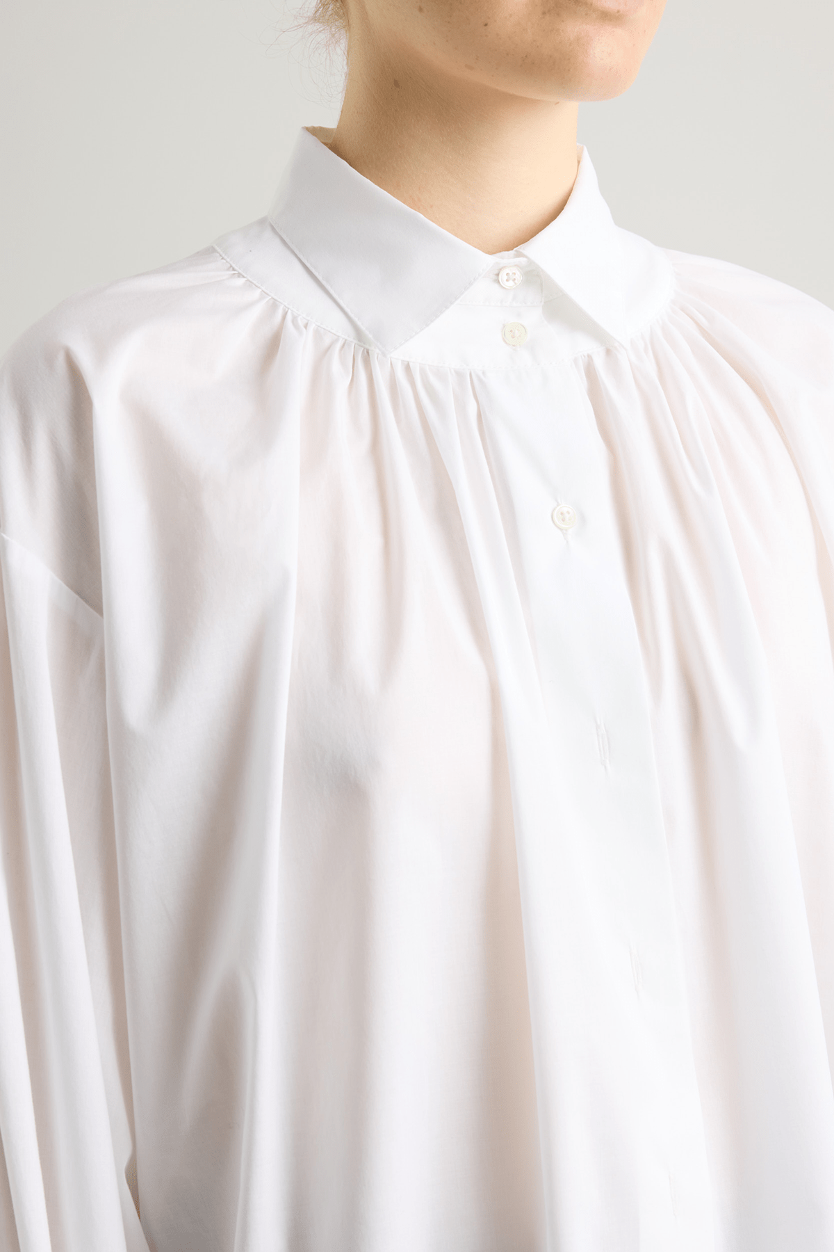 close up of a girl in a white button down shirt