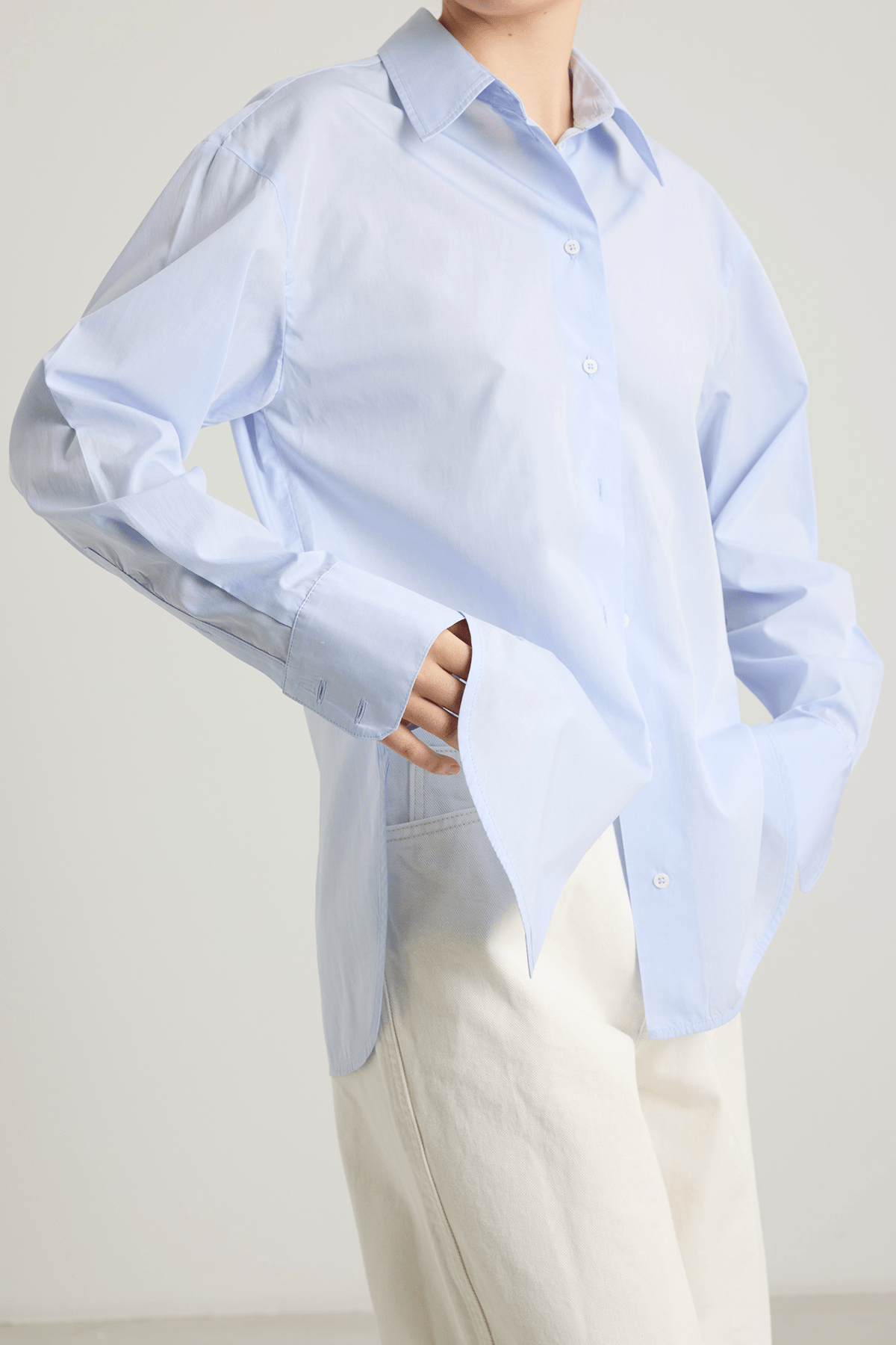girl in blue cotton button down shirt and white pants