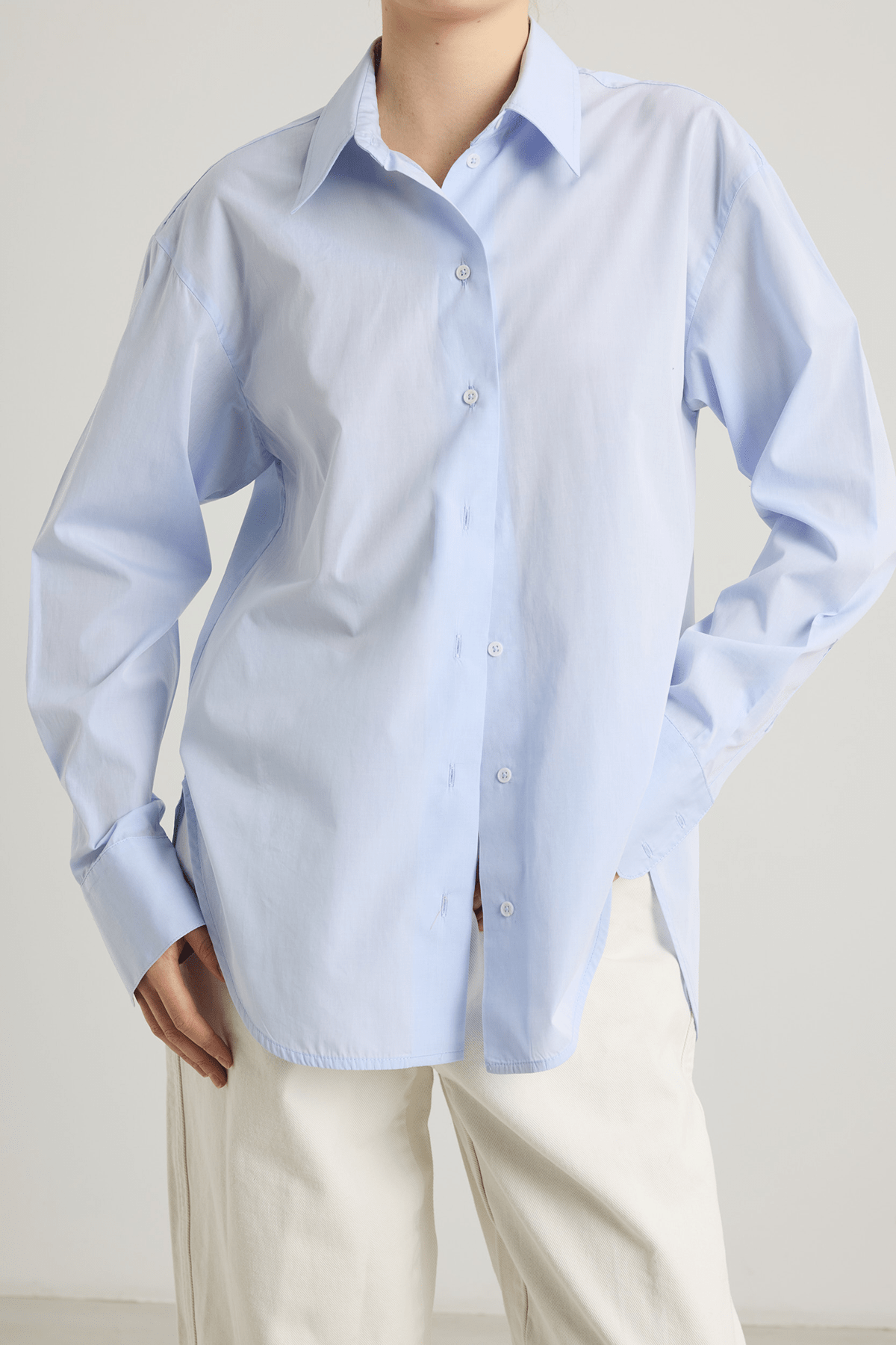 girl in blue cotton button down shirt and white pants