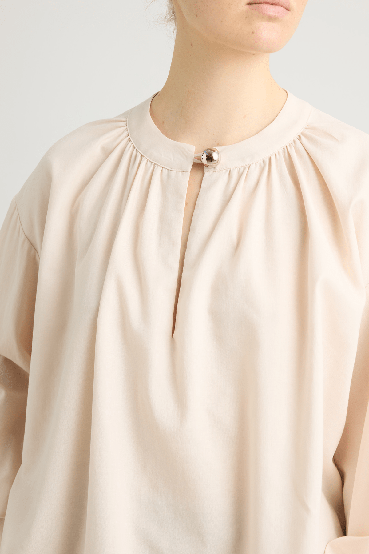 Cream blouse with a front button closure