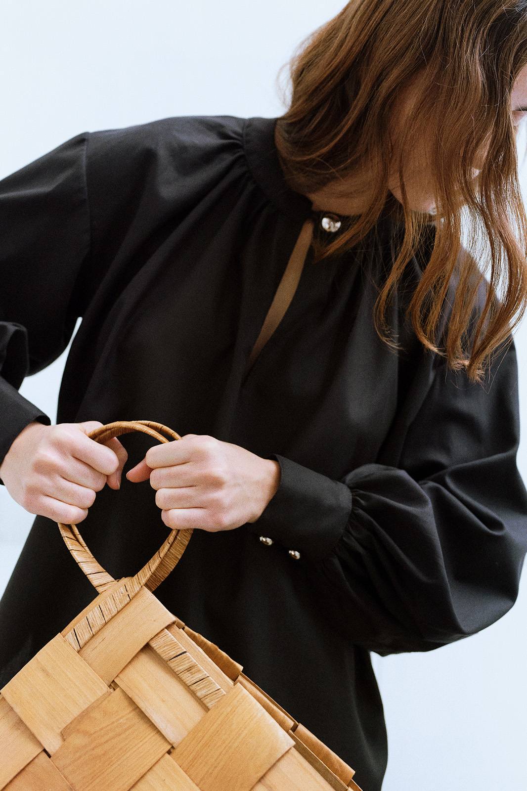 girl in Black blouse with a front button closure, and long voluminous balloon sleeves